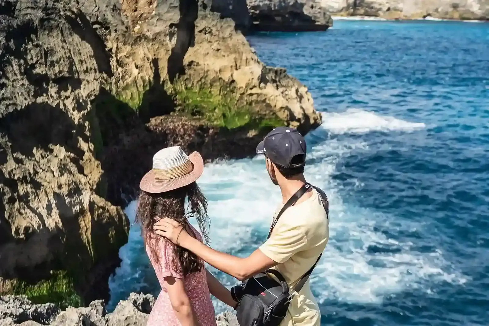 Two travellers in light clothes and hats on the rocks at Angel’s Billabong