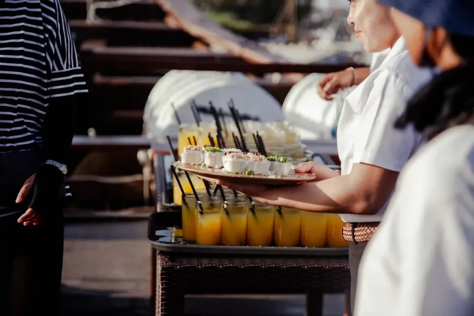 Crew serving welcome drinks to guests boarding a charter boat