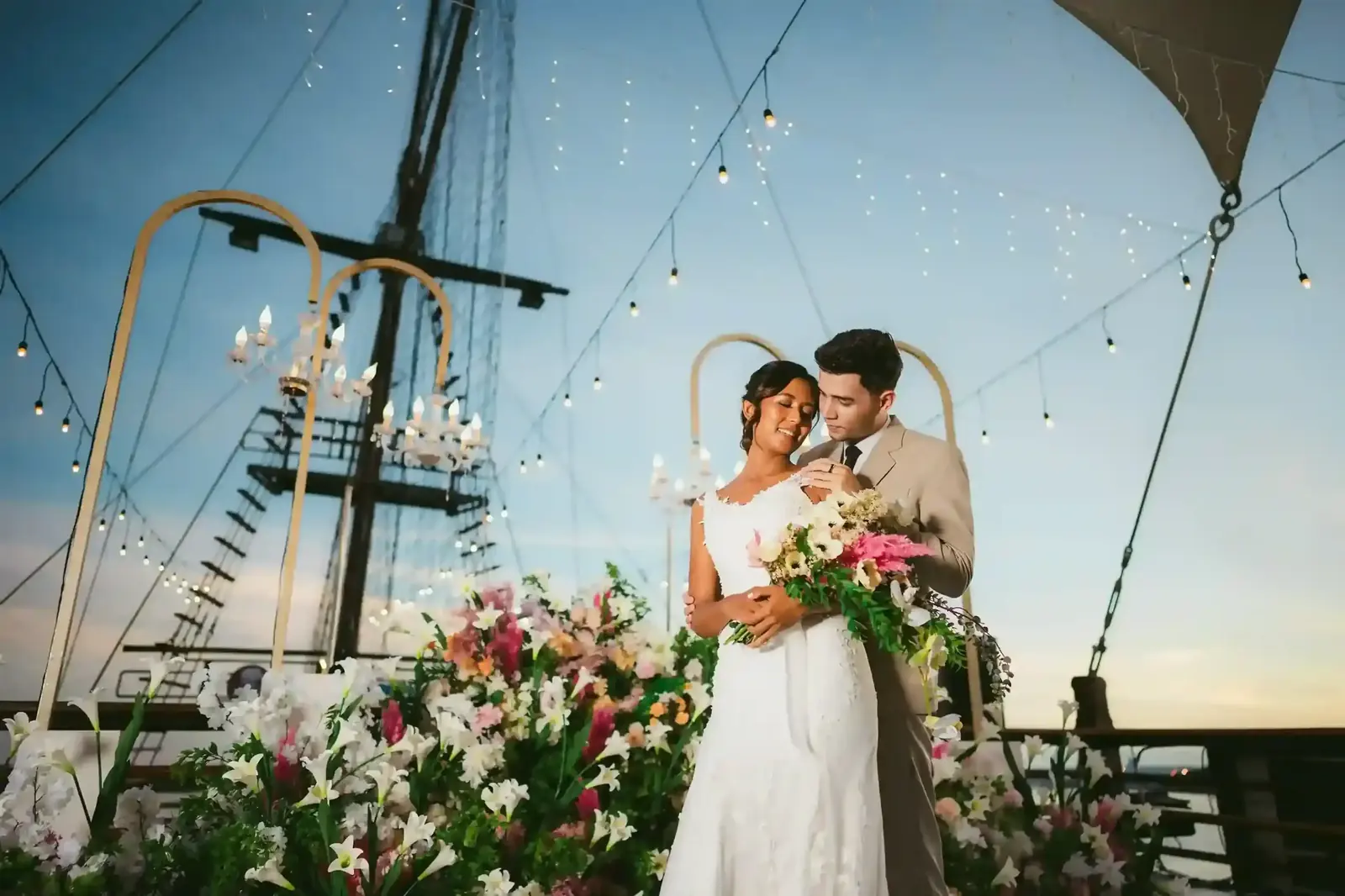 A couple celebrating on the deck of a traditional wooden schooner