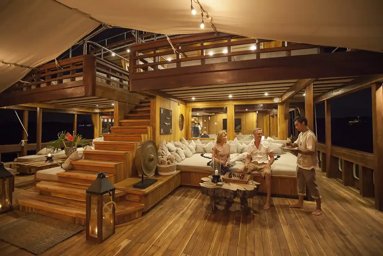 Crew looking after guests in the deck lounge of a phinisi