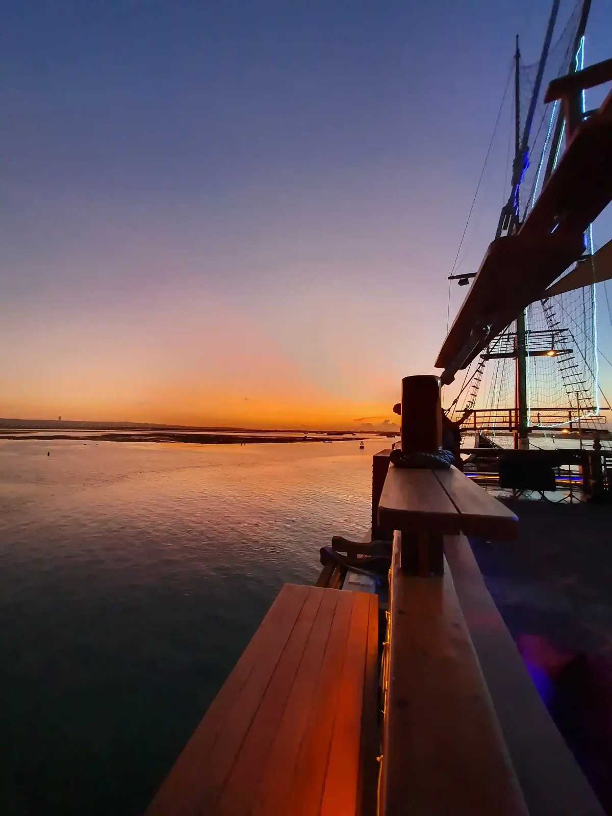 Sunset seen from the timber deck of a sailing ship