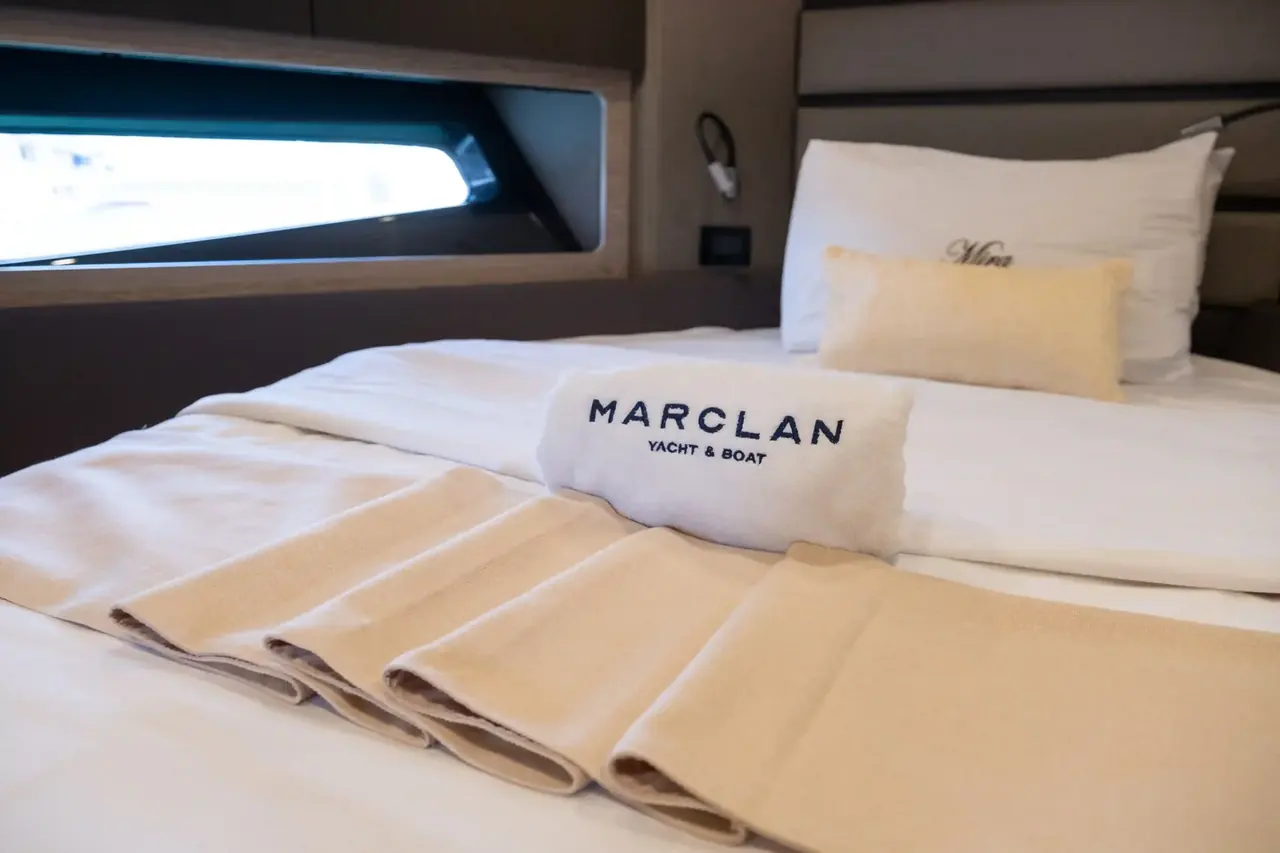 A made double bed in a sport yacht cabin