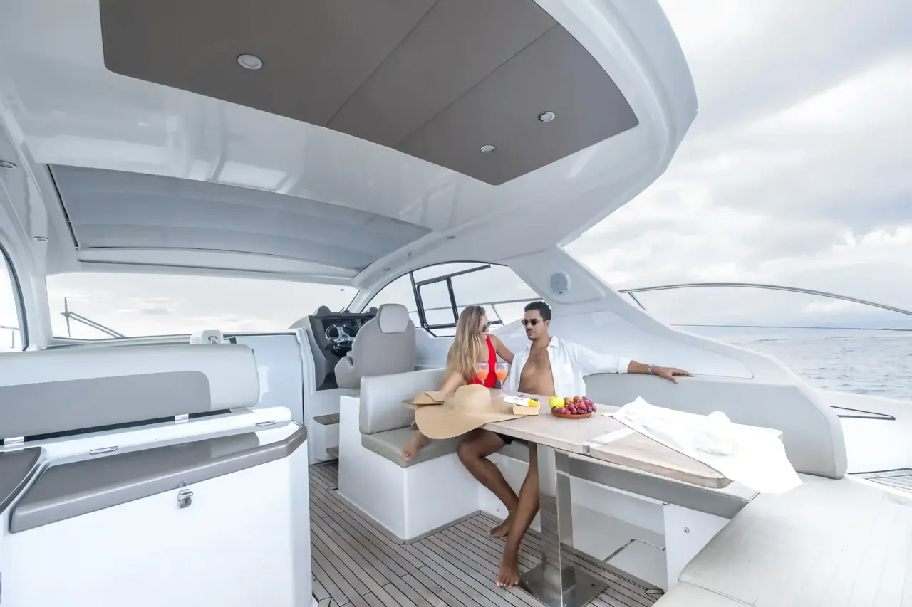 A couple sharing lunch at the table on the aft deck of a private yacht