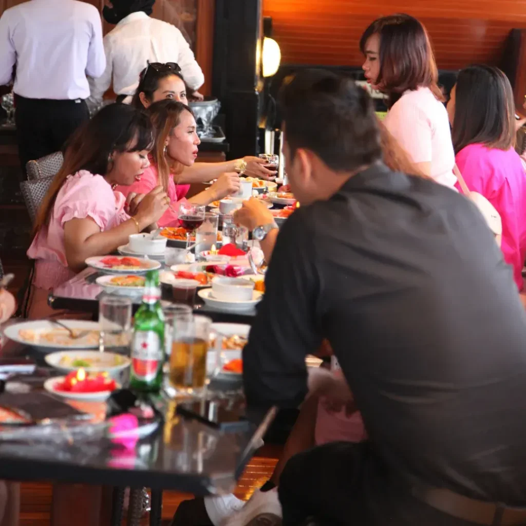 A group sharing lunch at a long table in the saloon of a charter boat